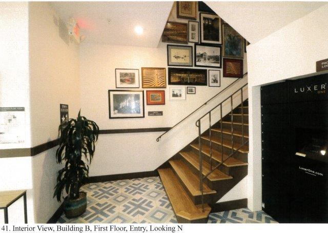 After: Interior view of entrance foyer stairs facing north with corridor blocked off to contain stairs inside foyer.